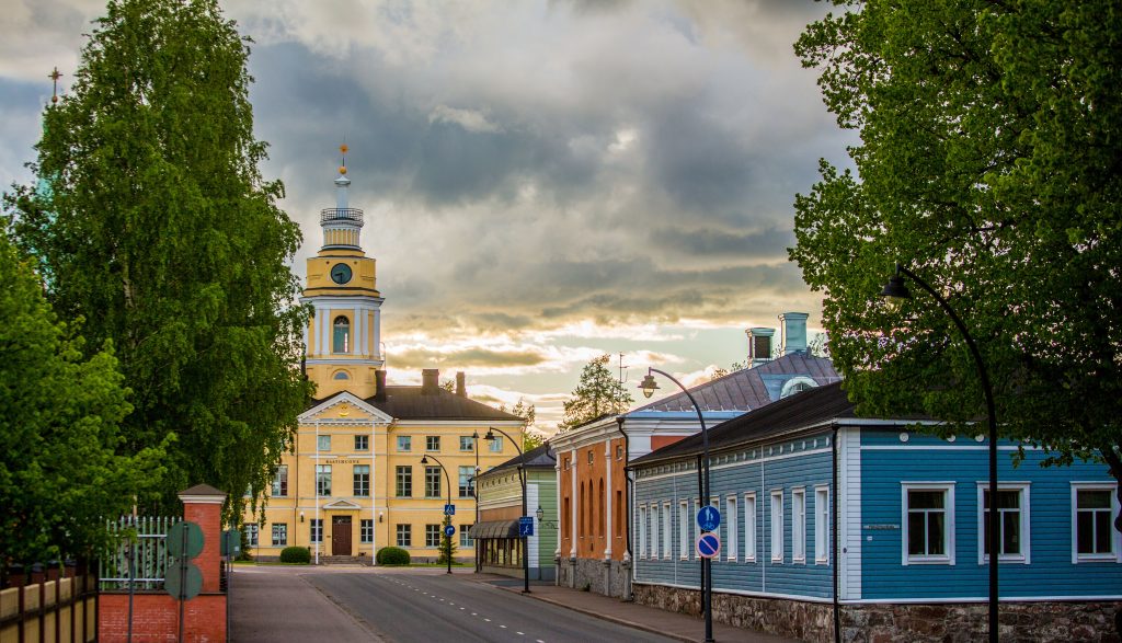 Keltainen raatihuone ja oikealla värikkäitä rakennuksia.