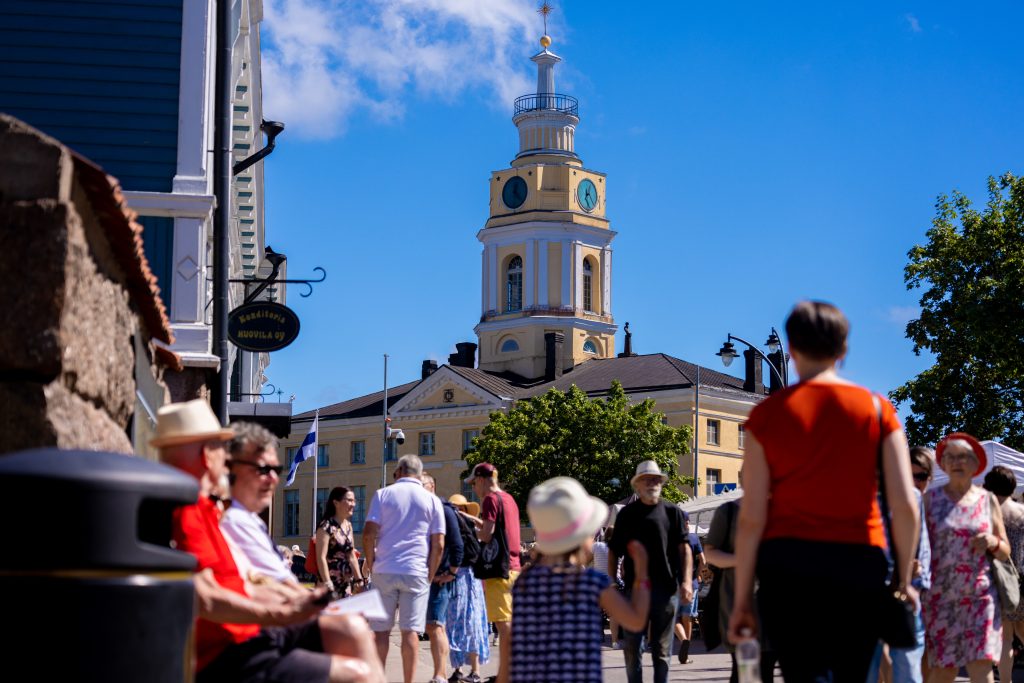 Ihmisiä kadulla. Raatihuone näkyy taustalla.