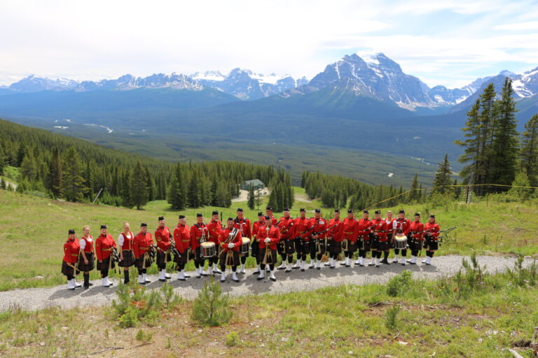 Kanadan kuninkaallisen ratsupoliisin säkkipilliorkesterin ryhmäkuva Kanadan vuoristomaisemissa.